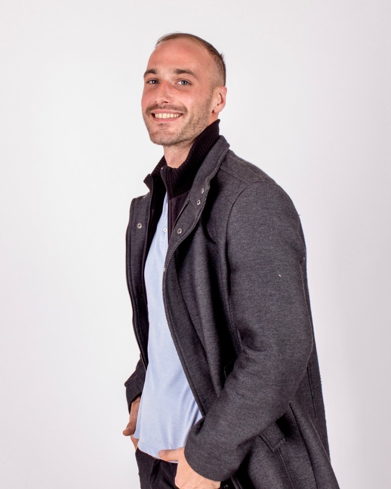 Lautaro Dagorret, sonriendo, con saco gris